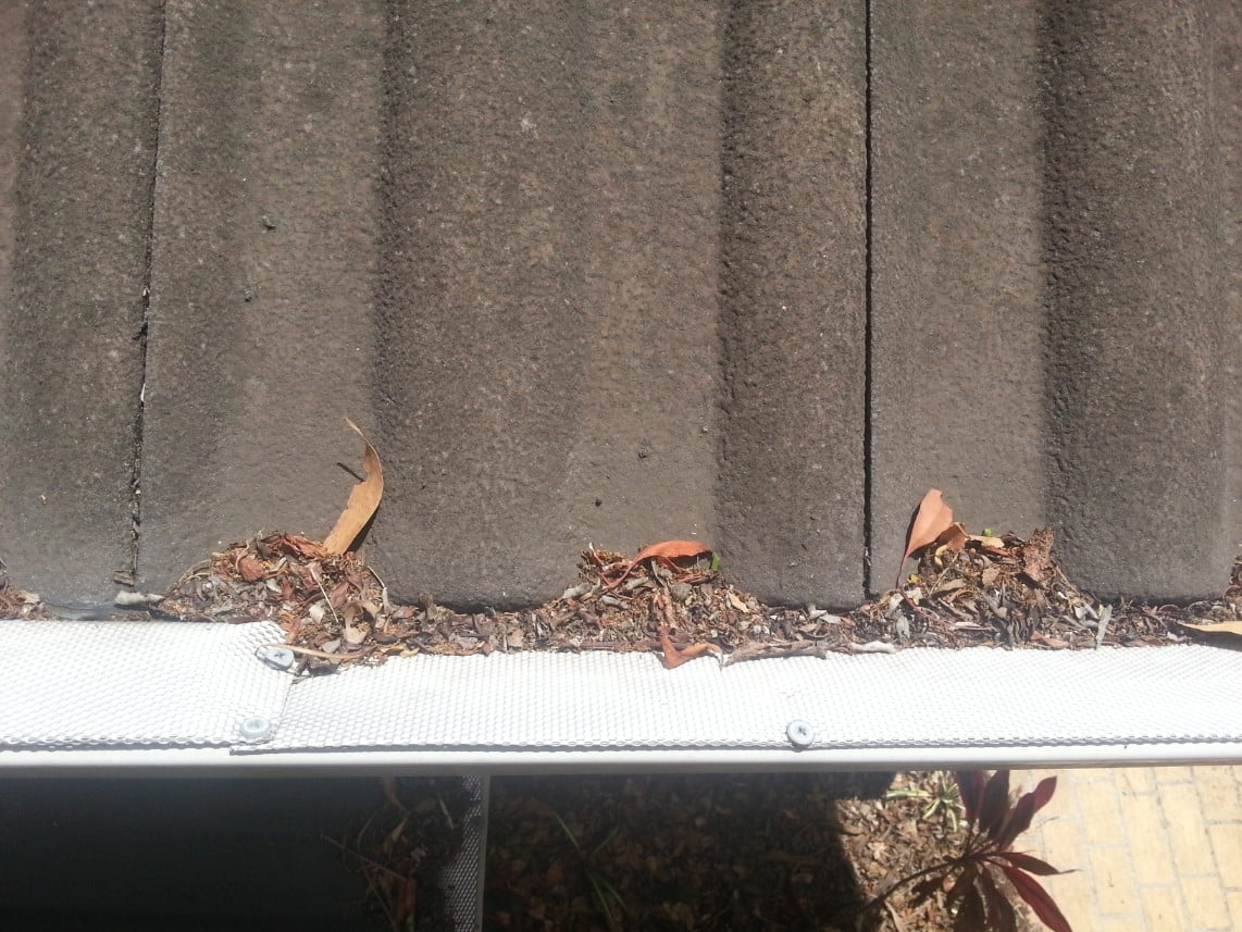 Steel guard that sits inside gutters blocks up and allows debris to slide under into gutters